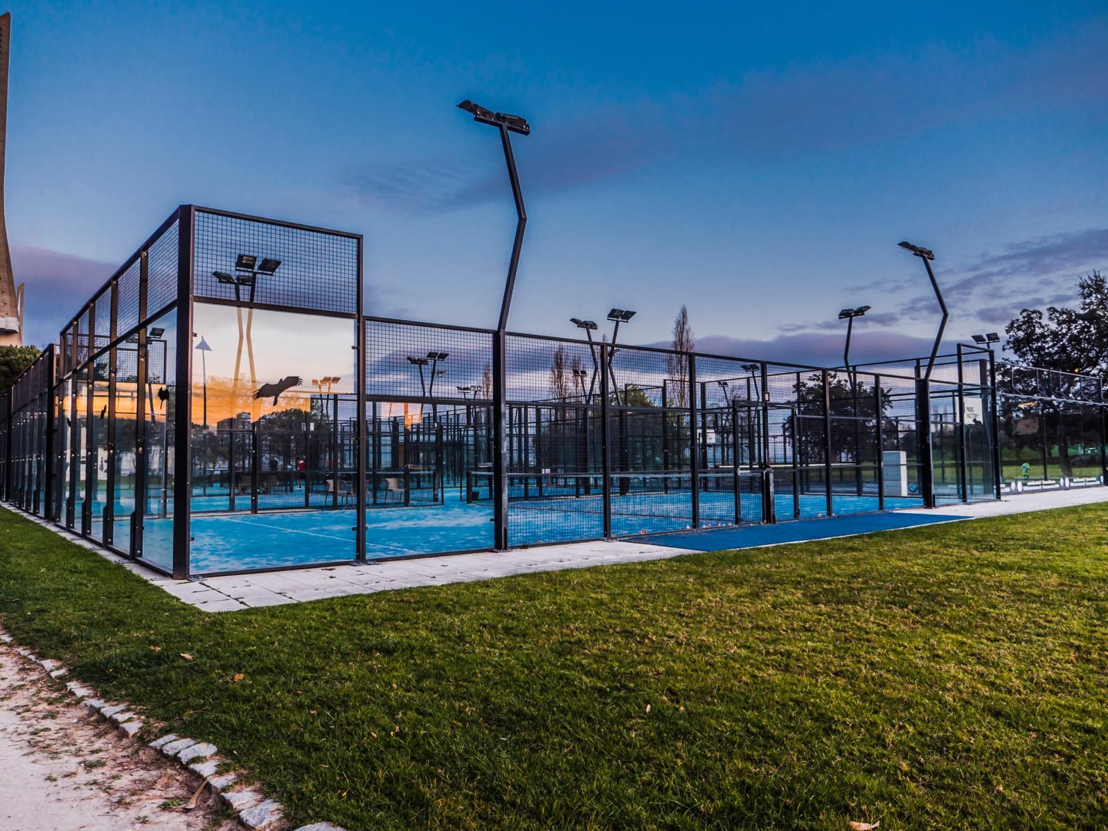 Floodlit outdoor padel courts at dusk
