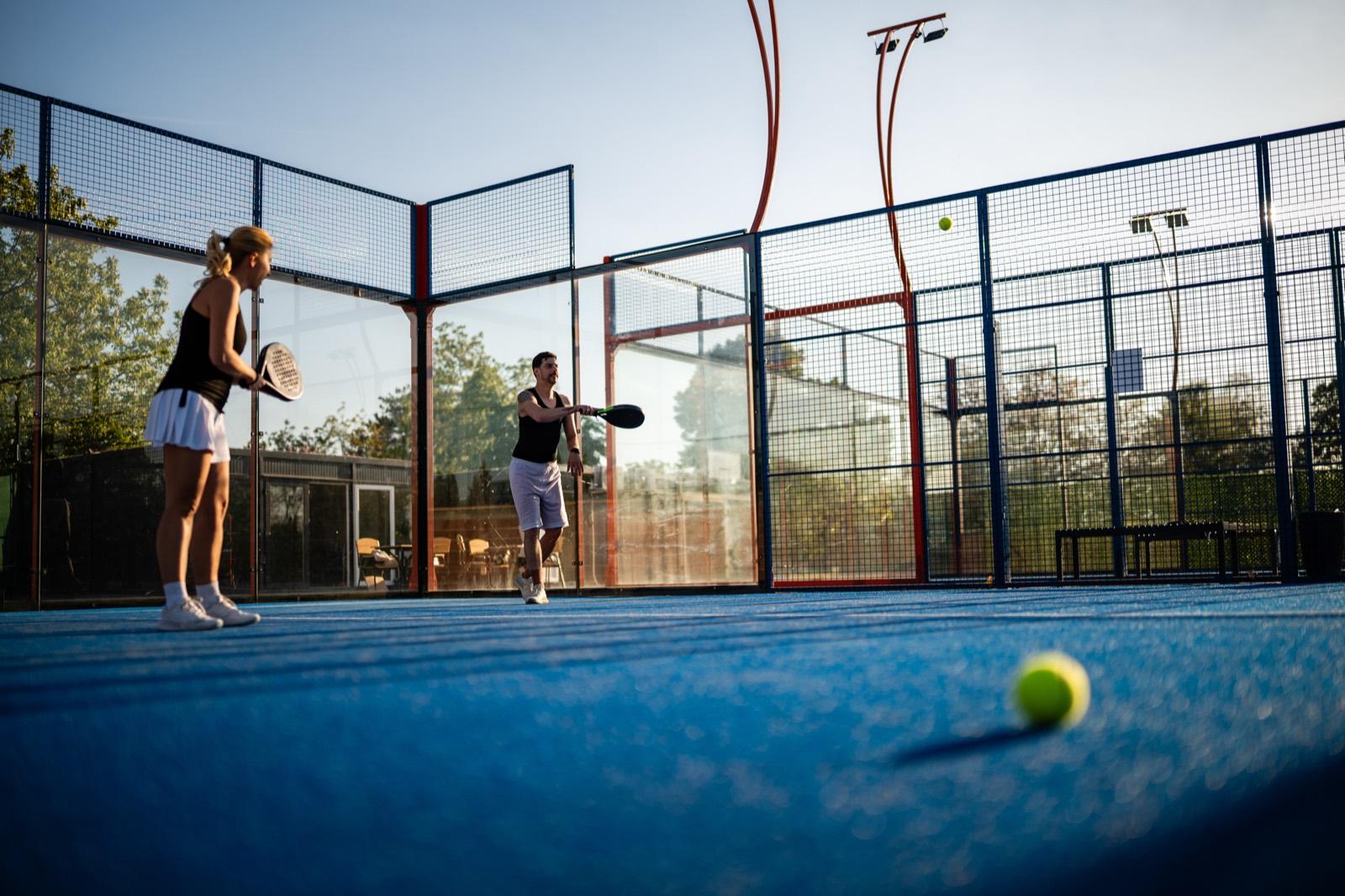 A padel match seen through the glass wall of an indoor court
